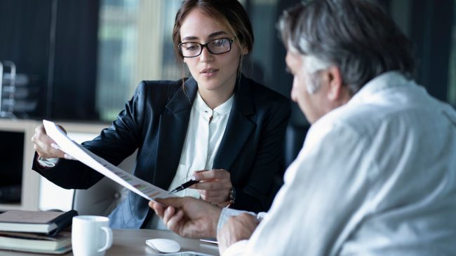 Photo of an HR consultant reviewing paperwork with a client