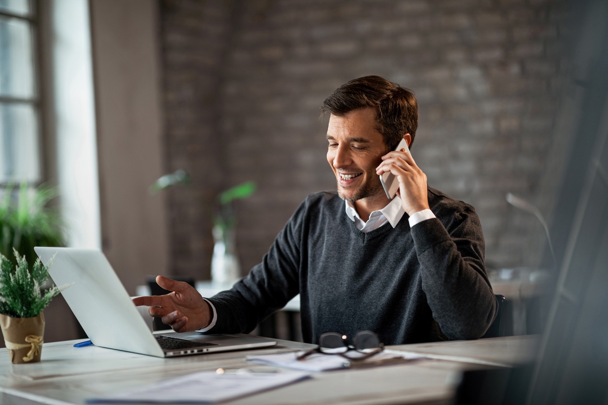 Photo of an Employee on the Phone and Computer